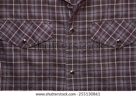 Fragment of the black and white, checkered, unbuttoned shirt with pockets useful as background