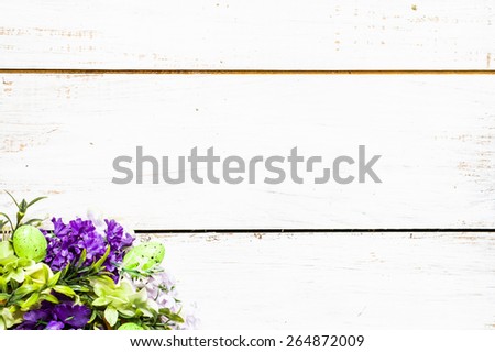 Arrangement of artificial flowers located on white wooden planks background useful as easter background and postcard