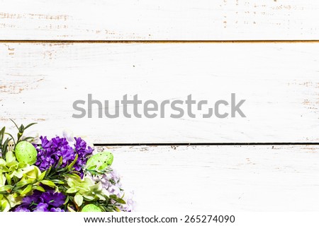 Arrangement of artificial flowers located on white wooden planks background useful as easter background and postcard
