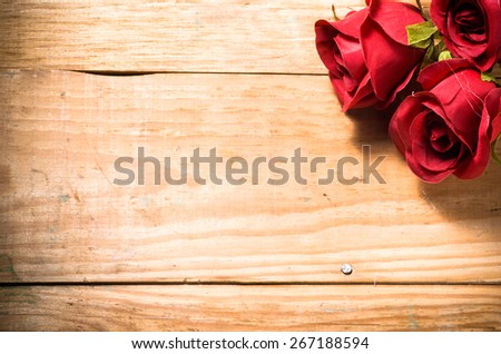 Red roses flowers on a vintage wooden planks background, greeting card and invitation cards