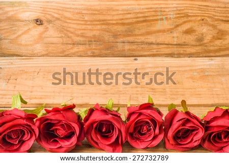 Romantic red roses flowers on a vintage wooden planks background for floral backgrounds, mothers day card, wedding invitation, greetings card, and invitation cards