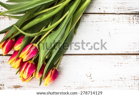 Tulips arrangement on aged wood planks background for wedding invitation, greetings card, birthday and invitations card