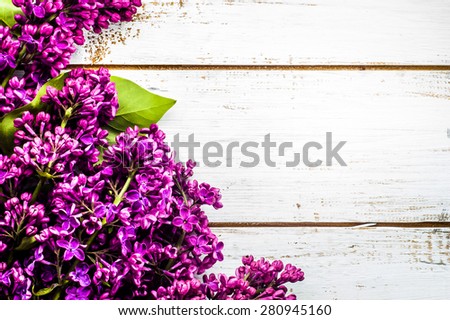 Lilac flowers on wooden planks background useful as greetings card, invitation cards, wedding invitation and postcards with place for text.