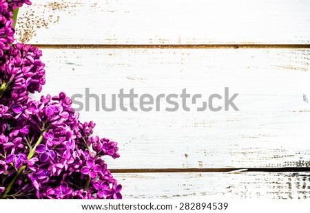 Lilac flowers on wooden planks background useful as greetings card, invitation cards, valentines cards, wedding invitation and postcards with place for text.