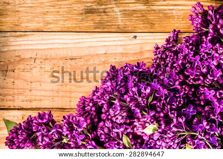 Lilac flowers on wooden planks background useful as greetings card, invitation cards, valentines cards, wedding invitation and postcards with place for text.