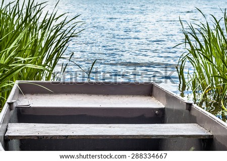 Rowing boat on the lake among the reeds. Outdoor wedding theme. Nature background.