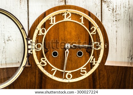Old vintage clock on wooden wall background. Time concept.