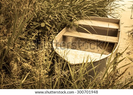 Vintage photo of boat for fishing on the lake at the shore. Summer holiday and vacation, leisure and relax. Nature background or landscape, vintage effect.