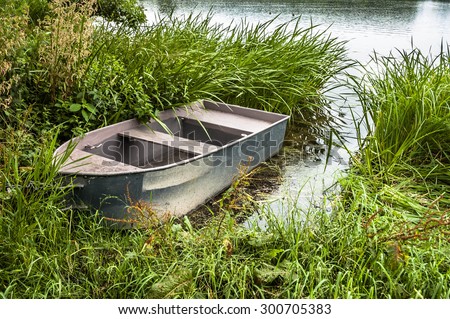 Boat for fishing on the lake at the shore among the reeds. Outdoor wedding theme. Theme of vacation, holiday, leisure and relax.