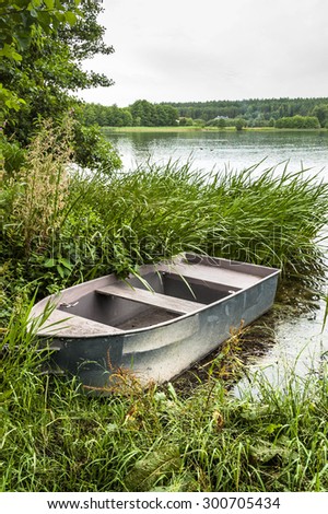 Boat for fishing on the lake at the shore among the reeds. Outdoor wedding theme. Theme of vacation, holiday, leisure and relax.