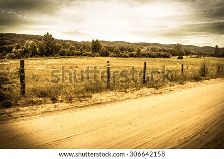 Landscape stylized on vintage with rural scene, rural road, fields and meadows at summer. Idyllic rural landscape and agricultural with vintage vignette effect.