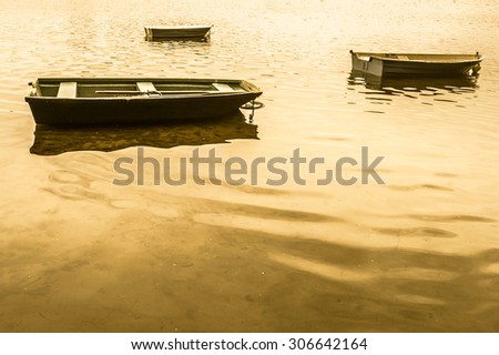 Vintage photo of old boat for fishing on the lake, quiet surface of water. Nature background, vintage effect.