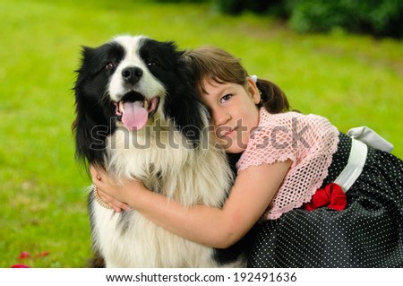 Vintage dressed little girl with border collie dog in the garden