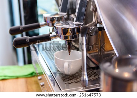 Coffee machine make coffee into coffee cup at coffee shop.