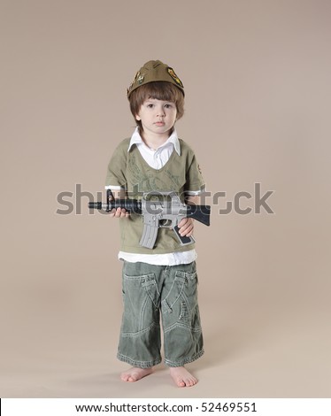 stock photo : Little boy in soldier's uniform with a gun. Studio shot