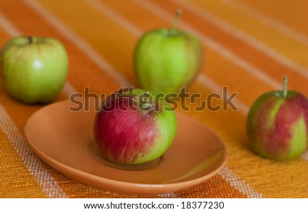 Four apples on orange background