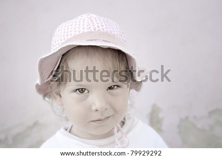 The smart looks of a little girl on a simple background