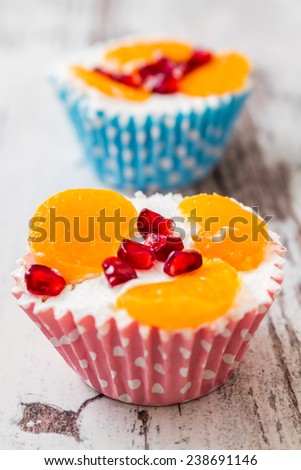 Cupcakes with fruit in blue and pink paper cupcake holders