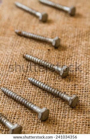Group of used and old screws on sack fabric