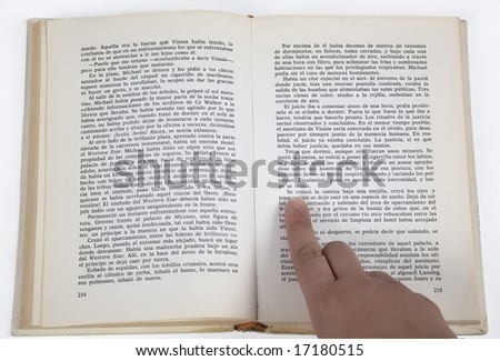 a finger pointing at the text of a book