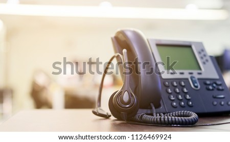 close up soft focus on telephone devices at office desk for customer service support (call center) concept