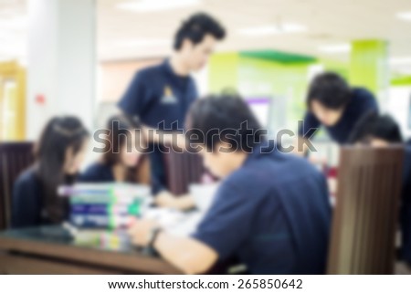 Blurred people reading in the library,blurred backgrounds concept.