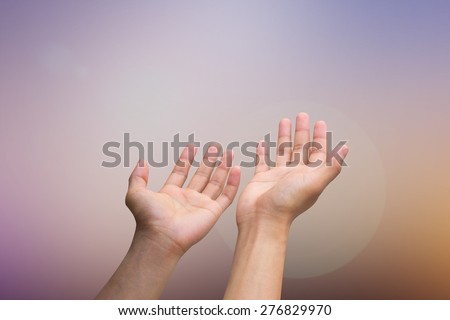 Human\'s hands pray on blurred nature background , soft focused