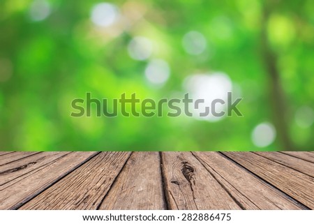 old vintage wooden desk table with blurred nature backgrounds,put and show your products on this backgrounds.
