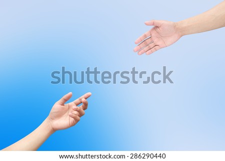 Human\'s hands help together on blurred blue sky  backgrounds.helping hand concept.