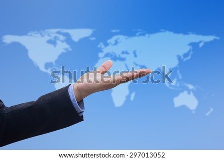 Businessman\'s hand showing over blurred map of the world on blurred blue backgrounds, selective focused.business concept.