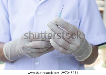 Close up hands of doctor wear gloves and preparing syringe for inject to cure patient.selective focused on hands.soft focused.
