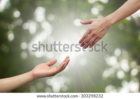 couple of helping hand and hand praying on blurred green nature background,spiritual of life ideal.supporting sustaining of humanity and religious:love togetherness:healing and assistance conceptual