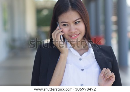 close up cute business woman talking on mobile phone at outside office : working woman love and happy to working, business woman concept,happy working concept.