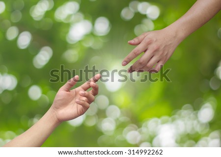 helping hand and hands praying on blurred green nature background : hand praying and hand blessing for helping each other:helping hand concept.religion concept.