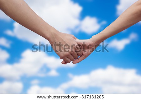 close up male and female hands holding together on blurred blue sky  background.passion in love concept ,soft focused.picture use for work about decorate,design.happy family concept.healthcare family.