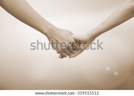 close up of human hands holding together for helping and cheer up : helping hands concept :family and friends concept.hand of power family.abstract helping hand in sepia vintage tone colors concept.