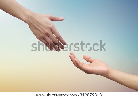 helping hand and hands praying on blurred beautiful twilight sky backgrounds. helping hand concept.hand of god giving the power to human's hand.
