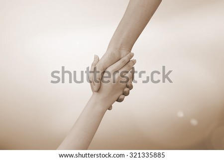 close up of human hands holding together for helping:helping hands concept :religion  concept.hand of god concept.abstract helping hand in sepia vintage tone colors concept.