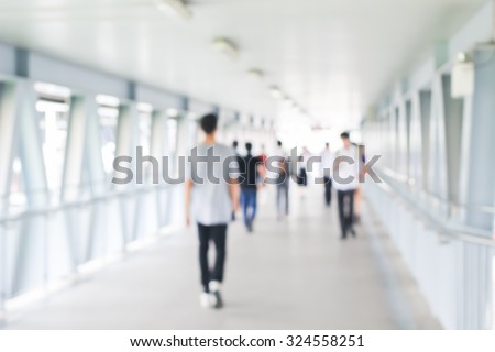 blurred of movement crowd people walking to the airport gate for travel or business:blur of indoor architecture concept:blurry people walking crowded conception.traveler concept.