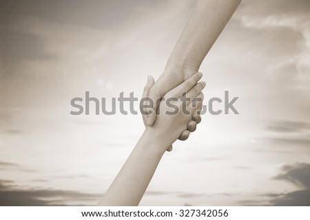 close up of human hands holding together for helping:helping hands concept :religion concept.hand of god concept.abstract helping hand in sepia vintage tone colors concept.