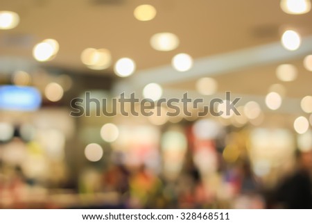 blurred light in warm tone backgrounds:blur of department store shopping concept: out of focus concept.pastel ton colored:blur of bokeh circle light christmas festive backdrop concept.