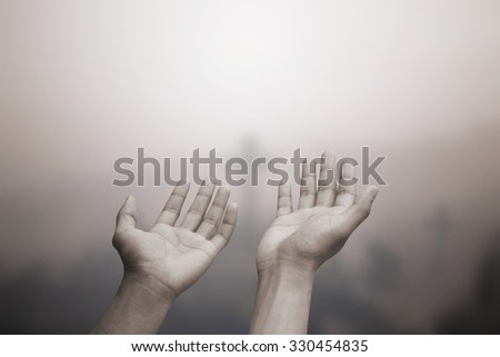 human\'s hands praying cross (symbols of Christ religious) on blurred churchyard background:hand of soul open receiving power from god.religion concept.human prayer concept.image in sepia tone colored.