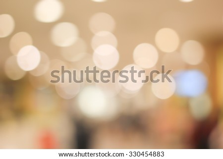 blurred light in warm tone backgrounds:blur of department store shopping concept: out of focus concept.pastel ton colored:blur of bokeh circle light christmas festive backdrop concept.