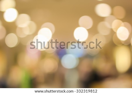 blurred light in warm tone backgrounds:blur of department store shopping concept: out of focus concept:blur of bokeh circle light christmas festive backdrop concept.golden hours conceptual.