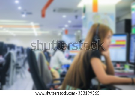 Blurred group of operator help-desk working on computer with headset:blur women operator talking for helping customers:working employees giving information:blur working women concept.