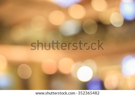 blurred glittering shining bubbles lamp lights in warm tone backgrounds:blur of department store shopping concept:out of focus concept.blurry Christmas golden and orange tangerine banner wallpaper.
