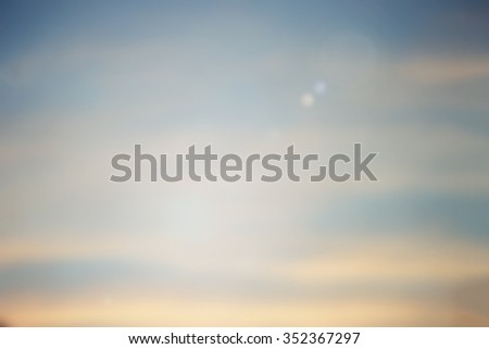 blurred background of evening city space sky with sunshine flare lights.blur vintage warm tone backdrop concept.shimmer glint shine illuminated sun ray.soft clouds dusk canopy of dream display.