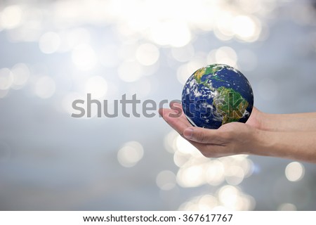 man hand gesture palm up holding world on blurred peaceful landscape water surface background:safe earth energy concept:people and ecology efficiency:healthcare of planet resource:help global together