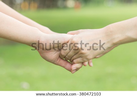 close up/selective focus of couple women take hands holding together for helping and cheer up:giving/supporting/encourage/care/love concept:family and friends concept.happy/hope/trust:girl handshake.