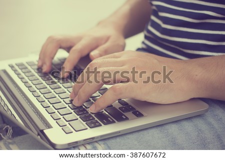 close up student type on keyboard notebook mobile portable device:man check update job email:work learn concept.education,technology.soft focus of hand gesture on keyboard:vintage tone effect filter